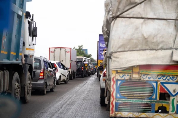 Довга смуга застряжного руху з автомобілями та велосипедами на вузькій дорозі, оскільки дорога заблокована фермерами поблизу кордону з Джайпур-Делі. — стокове фото