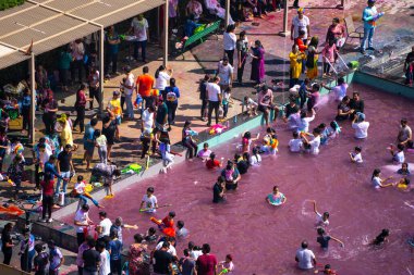 Delhi, Hindistan - 14. Mar 2025: Pembe renklerle dolu bir yüzme havuzunda Hindu Holi Festivali oynayan insanların yakınlaştırılmış görüntüsü