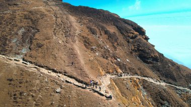 Uttarkhand, Hindistan - 20 Kasım 2025: Hava aracı insanları, Uttarakhand Hindistan bulutlarıyla kaplı en yüksek Shiv tapınağına ulaşmak için Chopta 'dan Tungnath Trek' in dar merdivenlerine tırmanmaya adanmıştır.