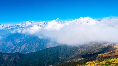 Hava aracı, Uttarakhand Hindistan 'daki Chopta Tungnath yürüyüşünün güzelliğini gösteren Nepal' deki Annapurna tepelerini karla kaplayan bulut örtülü Himalaya dağlarını vurdu.