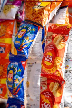 Delhi, Hindistan - 22 Aralık 2023: Hindistan 'da satılan Lays markalarını gösteren bir mağazanın rafında asılı duran paket cips
