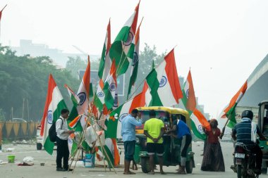 Delhi, Hindistan - 15 Ağustos 2025: Bağımsızlık Günü arifesinde şehrin sokaklarında Hint bayrağı satılıyor, çoğu zaman da bunun önemli bir gelir kaynağı olan yoksul geçmişlerden gelen satıcılar tarafından.