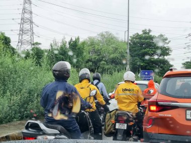 Mumbai, Hindistan - 10 Temmuz '25: Hindistan' ın başlangıcından gelen teslimatçı hızlı ticaret için 10 dakikalık teslimat sunuyor. Hiperyerel Blinkit yağmurda sıkıştı ve iş ekonomisi işçilerinin karşılaştığı zorlukları gösteriyor