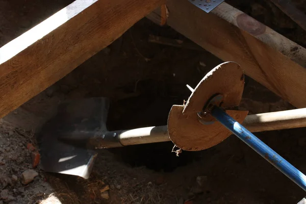 Drilling holes for posts in the ground with a garden drill in hard-to-reach places