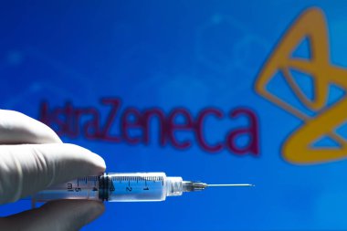 11 Kasım 2020, Brezilya. Bu resimde tıbbi şırınga (coronavirus aşısı), arka planda bir ekranda AstraZeneca PLC şirket logosu sergilenmektedir.