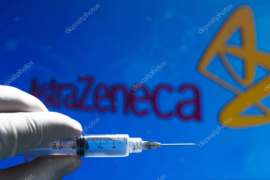 November 11, 2020, Brazil. In this photo illustration the medical syringe (coronavirus vaccine) is seen with AstraZeneca PLC company logo displayed on a screen in the background