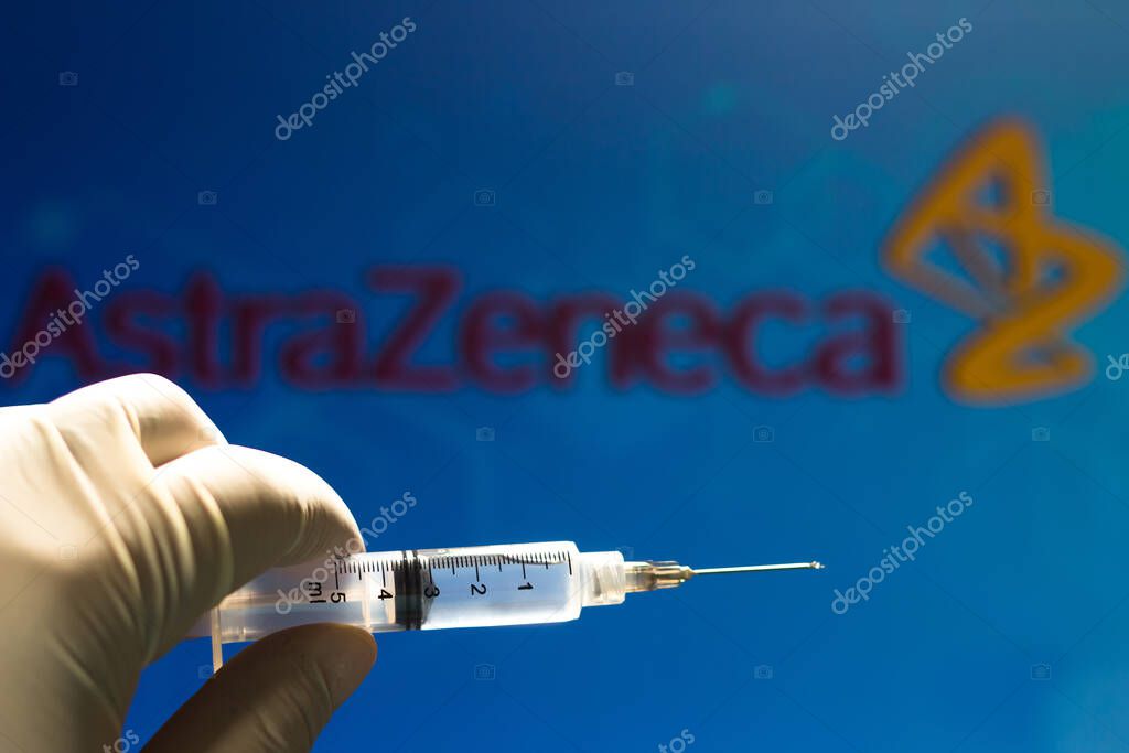 November 11, 2020, Brazil. In this photo illustration the medical syringe (coronavirus vaccine) is seen with AstraZeneca PLC company logo displayed on a screen in the background