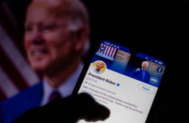 25 Ocak 2021, Brezilya. Bu resimde Amerika Birleşik Devletleri Başkanı Joe Biden 'ın resmi sayfası, Twitter' da arka planda video parçalarıyla birlikte akıllı bir telefonla görüntülendi.