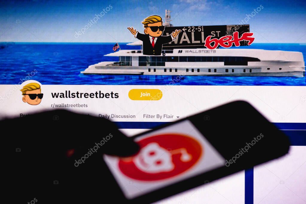 February 1, 2021, Brazil. In this photo illustration the WallStreetBets page Reddit seen in the background of a silhouette hand holding a mobile phone