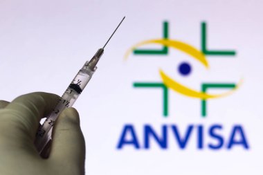 30 Mart 2021, Brezilya. Bu resimde tıbbi şırınga, arka planda bir ekranda Ulusal Sağlık İzleme Ajansı (Anvisa) şirket logosu ile görüntülenmektedir.