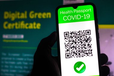5 Nisan 2021, Brezilya. Bu resimde, Avrupa Komisyonu önünde dijital yeşil sertifika oluşturma önerisi hakkında bir akıllı telefon ekranında gösterilen sembolik bir COVID-19 sağlık pasaportu