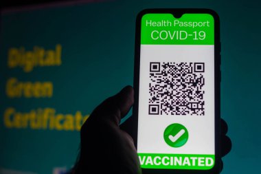 5 Nisan 2021, Brezilya. Bu resimde, Avrupa Komisyonu önünde dijital yeşil sertifika oluşturma önerisi hakkında bir akıllı telefon ekranında gösterilen sembolik bir COVID-19 sağlık pasaportu