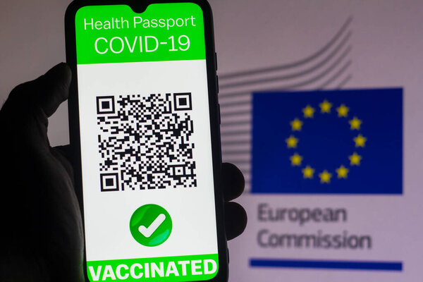 April 5, 2021, Brazil. In this photo illustration, a symbolic COVID-19 health passport seen displayed on a smartphone screen in front of the European Commission (EC) flag