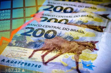 İki yüz Brezilya gerçekliğinin banknotları. Grafikler ve gerçek banknotlarla borsa. Brezilya ekonomisinin mali konsepti