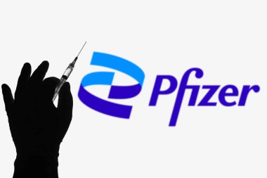 8 Nisan 2021, Brezilya. Bu resimde tıbbi şırınga ve Pfizer şirketinin logosu arka planda bir ekranda görülüyor.