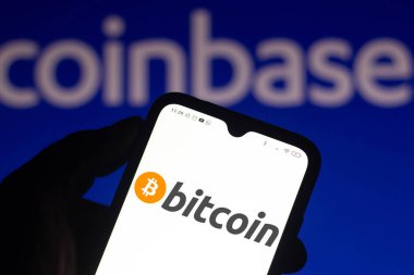 14 Nisan 2021, Brezilya. Bu resimde Bitcoin logosu arka planda Coinbase logosu olan bir akıllı telefon ekranında görüntülendi