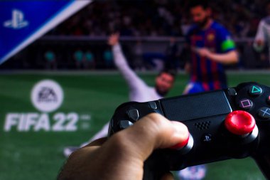 17 Mayıs 2021, Brezilya. Bu resimde PlayStation (PS) için denetleyici ve arka planda oyun logosu FIFA 22