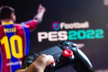 17 Mayıs 2021, Brezilya. Bu resimde PlayStation (PS) ve arka planda EFootball Pro Evolution Soccer (PES 2022) oyun logosu denetleyicisi)