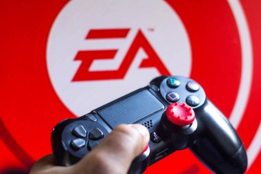 17 Mayıs 2021, Brezilya. Bu resimde PlayStation (PS) için denetleyici ve arka planda şirket logosu Elektronik Sanatlar (EA)