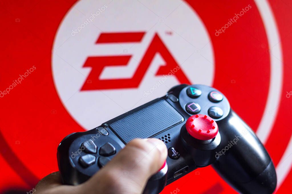 May 17, 2021, Brazil. In this photo illustration the controller for PlayStation (PS) and in the background the company logo Electronic Arts (EA)