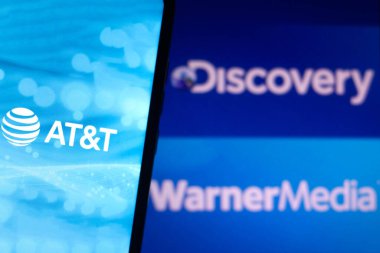 23 Mayıs 2021, Brezilya. Bu resimde AT & T logosu akıllı telefon ekranında gösteriliyor. Arka planda, Discovery ve Warner Media logoları