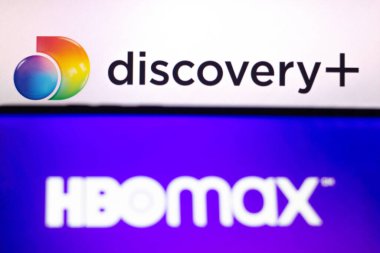 23 Mayıs 2021, Brezilya. Bu resimde arka plandaki akıllı telefondan görülen HBO Max logosu Discovery + (Plus) logosu