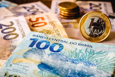 Bu resimde elli, yüz iki yüz reais banknot ve altı çizilmiş bir reais sikke gösteriliyor. Real, Brezilya 'daki mevcut para.