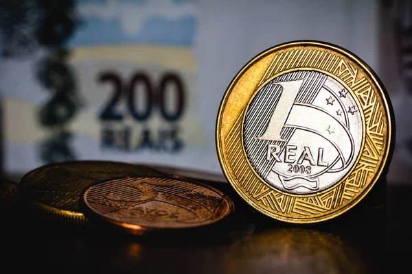 In this illustration photo the one real coin is placed on top of the two hundred Brazilian real note