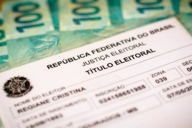 12 Ağustos 2021, Brezilya. Bu resimde seçmen belgesi (Ttulo Eleitoral). Fotoğraf seçim kartı (seçmen kimliği). Arka planda 100 reais fatura.