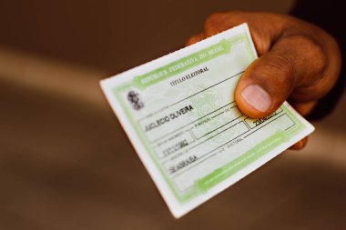 1 Eylül 2021, Brezilya. Bu resimde adam seçmen lisansını (Ttulo Eleitoral) elinde tutuyor. Brezilya seçimlerinde oy kullanabileceğini kanıtlayan bir belge..