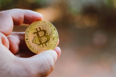 8 Eylül 2021, Brezilya. Bu resimde bir adam Bitcoin altın sikkesi sergiliyordu.