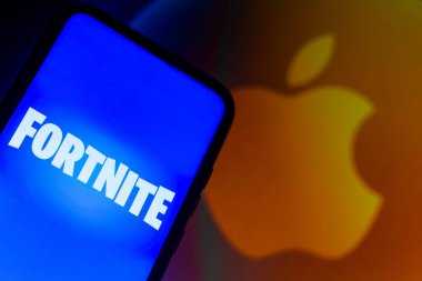 September 13, 2021, Brazil. In this photo illustration the Fortnite logo seen displayed on a smartphone with a Apple logo in the background clipart