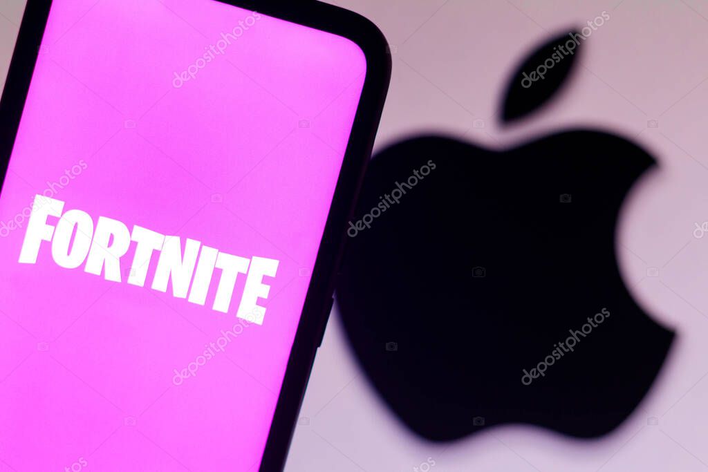 September 13, 2021, Brazil. In this photo illustration the Fortnite logo seen displayed on a smartphone with a Apple logo in the background