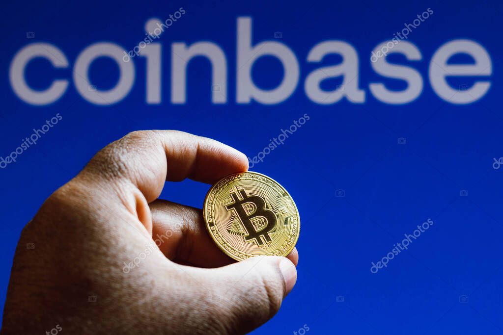 September 15, 2021, Brazil. In this photo illustration a Bitcoin seen on display in a man's hand, in the background the Coinbase logo