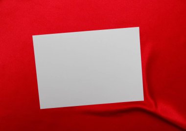 Kırmızı bir masa örtüsü üzerinde boş bir sayfa.