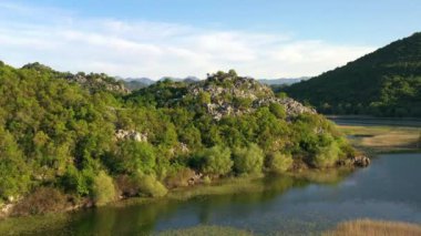 Karadağ 'ın baharda Skadar Gölü Milli Parkı' nda yeşil ağaçlar ve çalılarla kaplı kayaların ve dağların hava manzarası