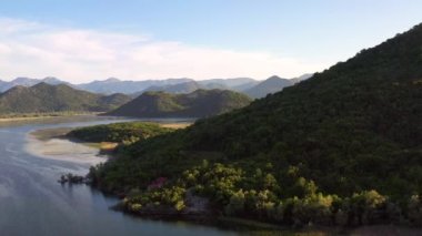Karadağ 'ın baharda Skadar Gölü' nün sularındaki yeşil dağların havadan görünüşü