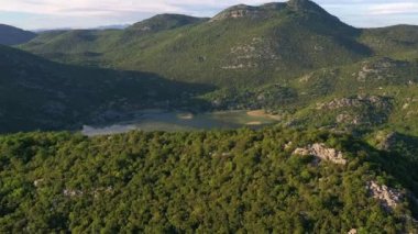 Karadağ 'ın baharda Skadar Gölü' nün sularındaki yeşil dağların panoramik manzarası
