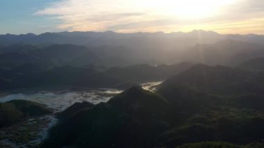 Karadağ 'ın gün batımında Skadar Gölü' nün sularındaki yeşil adaların hava manzarası