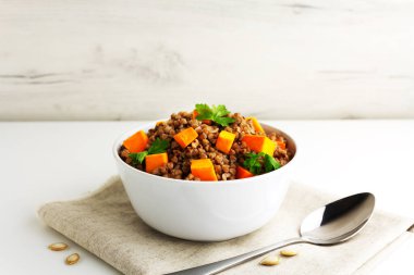 Kabaklı karabuğday lapası ve beyaz kasede pasley.