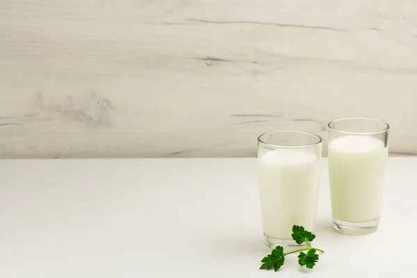 Kefir, ayran, yoghurt in glasses with greens — Stock Photo, Image