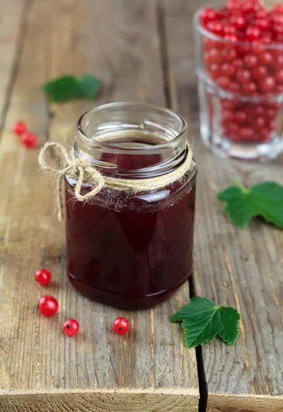 Rote Johannisbeermarmelade im Glas auf hölzernem Hintergrund — Stockfoto