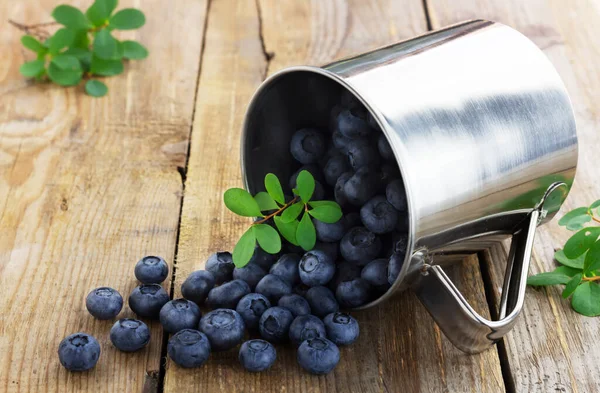 Frische Blaubeeren im Metallbecher auf Holzgrund — Stockfoto