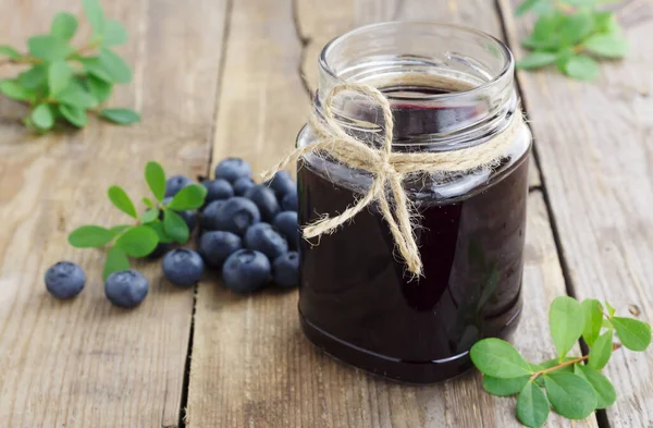 Blaubeermarmelade und frische Blaubeeren auf Holzgrund — Stockfoto