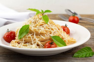 Domates soslu makarna, kiraz domates ve fesleğen. Kapat.