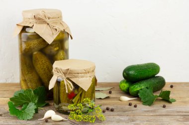 Ahşap masada cam kavanozlarda salatalık turşusu.