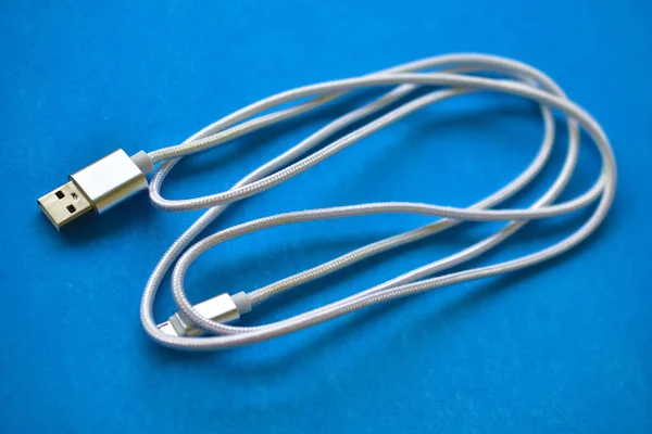 White USB cable on a blue background