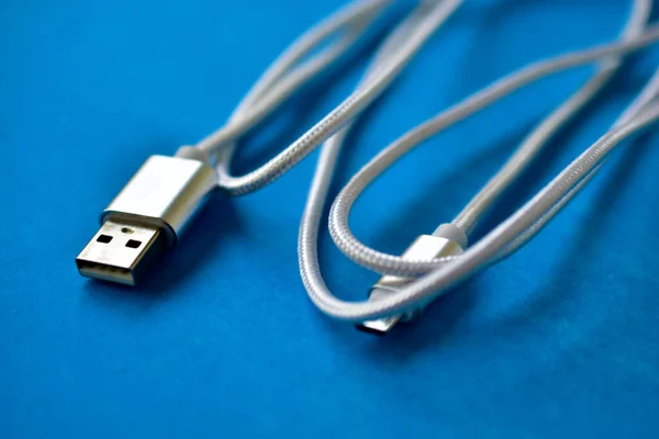 White USB cable on a blue background