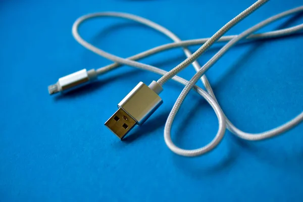 White USB cable on a blue background