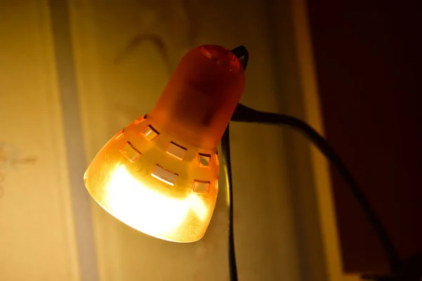 Yellow lamp in a dark room close-up